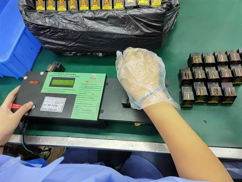 Worker running electrical test on ink cartridges